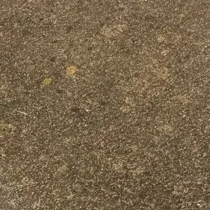Close-up of the brick surface before cleaning, dark brown and dulled.